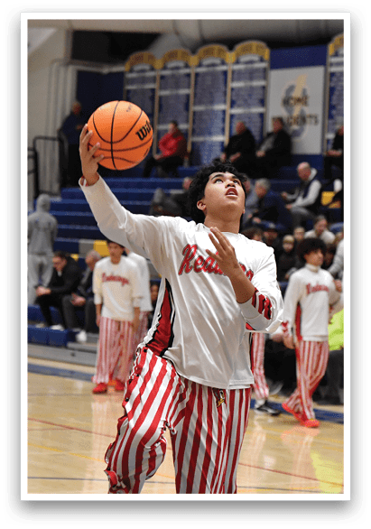 A basketball player in a white and red striped uniform is holding a basketball in the air, preparing to shoot. AI generated content