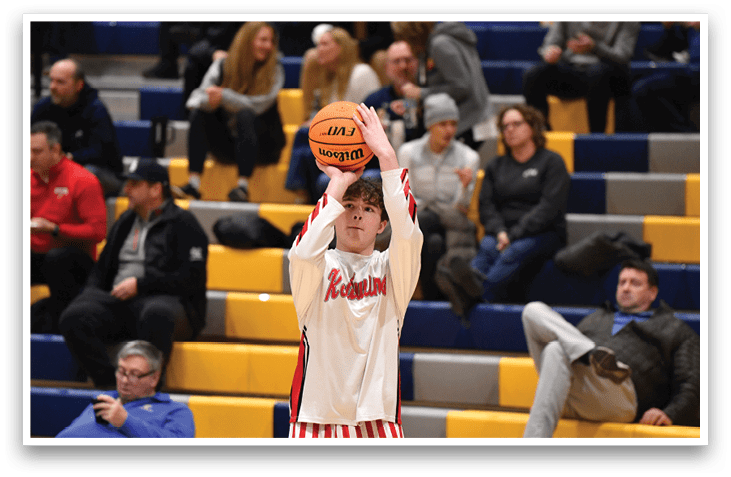 A boy in a red and white striped shirt is holding a basketball in front of a crowd of people. AI generated content