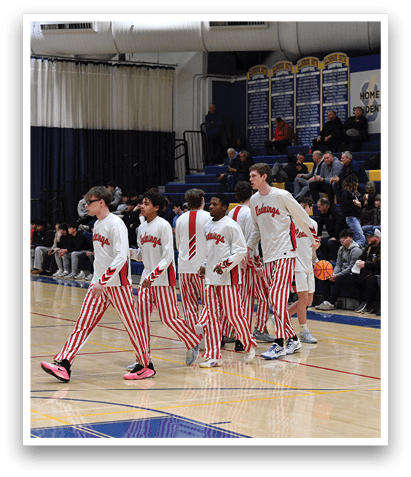 A group of basketball players wearing red and white striped pants are walking on a basketball court. AI generated content