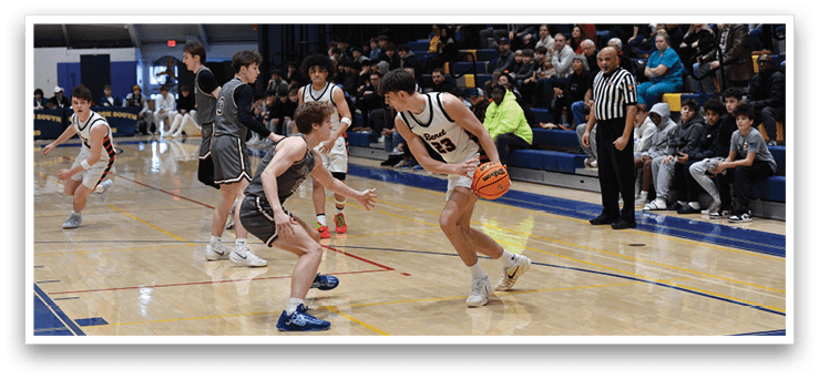 A basketball game is taking place with a group of young men playing. One player is holding a basketball while another player is trying to block him. The players are wearing uniforms and are actively engaged in the game. AI generated content