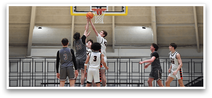A group of young men playing basketball, with one player jumping to block a shot. AI generated content