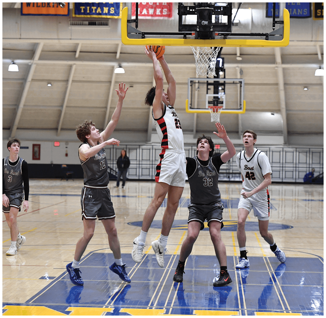 A group of young men playing basketball on a court. One player is jumping to block a shot. AI generated content