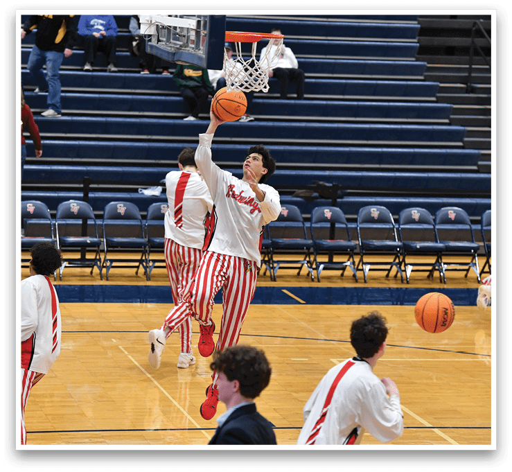 A group of men in red and white striped pants are playing basketball. One man is jumping to hit the basketball through the hoop. AI generated content