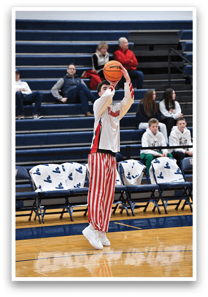 A man in a striped shirt and red and white socks is holding a basketball. AI generated content