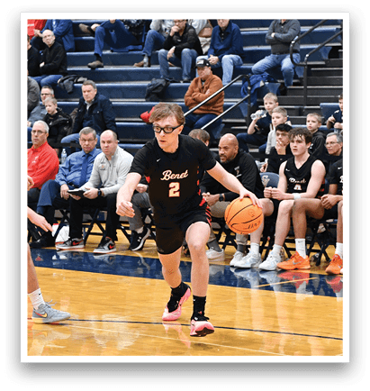 A basketball game is in progress with a player in a black shirt running with the ball. The crowd watches intently as the players compete. AI generated content