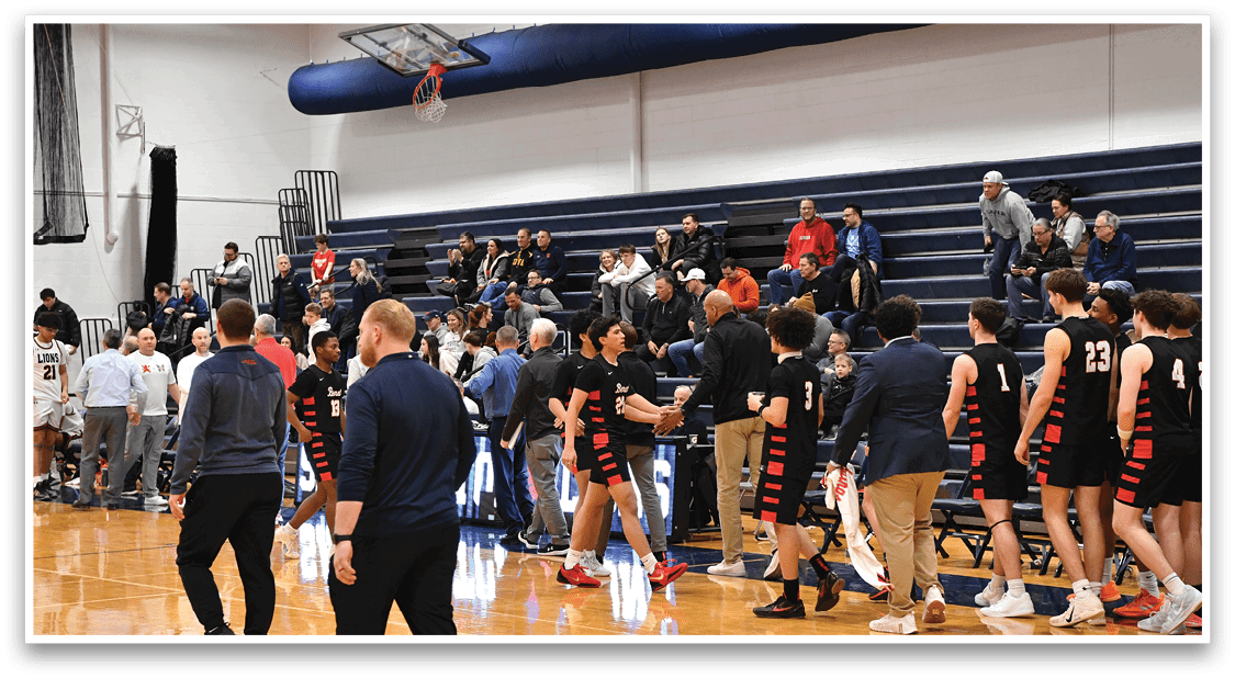 A group of people are standing in a gym, some of them wearing black and orange uniforms. They are holding their bags and are likely waiting for a game to start. AI generated content