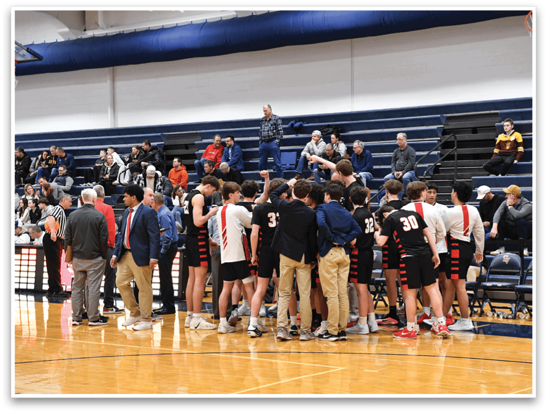 A group of young men are standing on a basketball court, huddled together. AI generated content