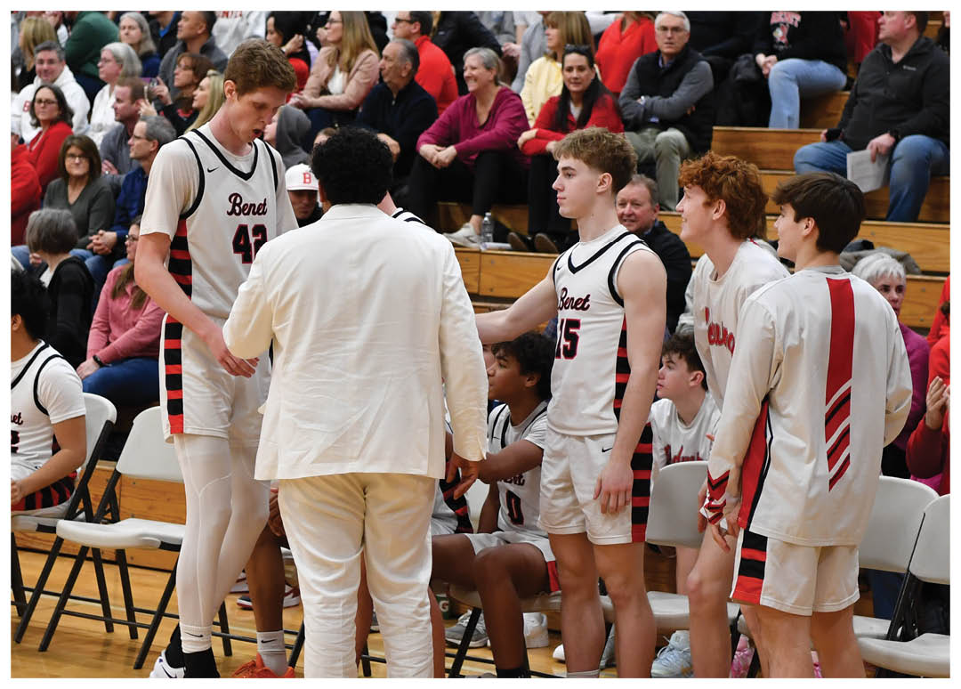 A group of young men in white uniforms are standing on a basketball court, talking to each other. They are surrounded by a crowd of people who are watching the game. AI generated content