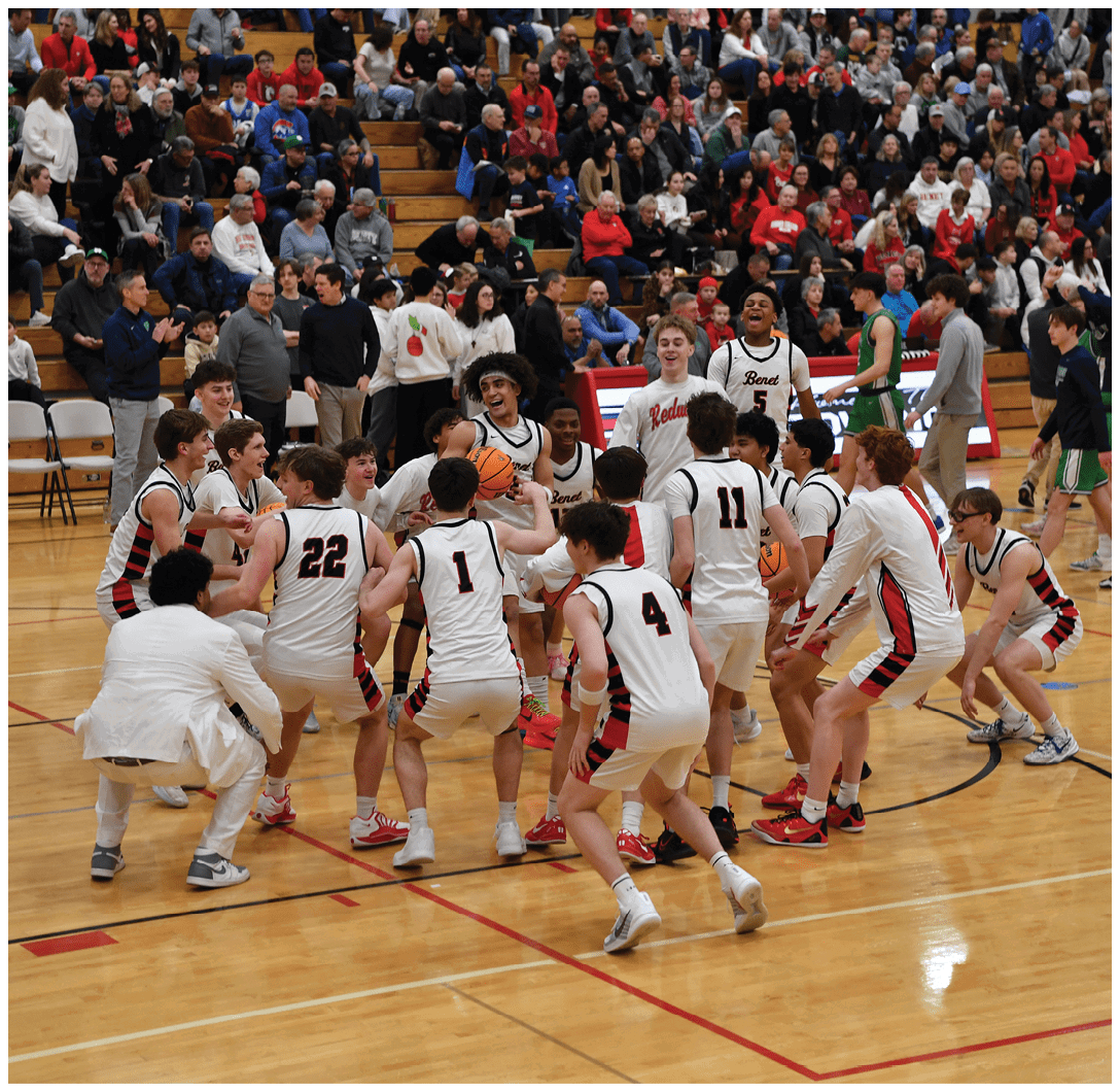 A group of young men are playing basketball on a court, with one player holding the ball. They are surrounded by a crowd of spectators. AI generated content