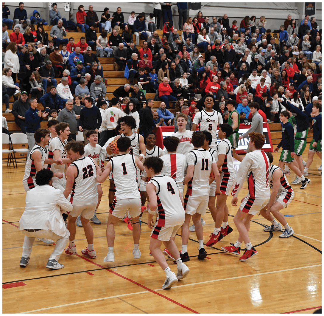 A group of young men are hugging each other on a basketball court, with a crowd of people watching from the stands. AI generated content