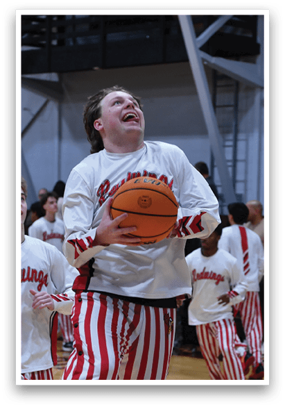 A basketball player is holding a basketball while wearing striped pants. AI generated content