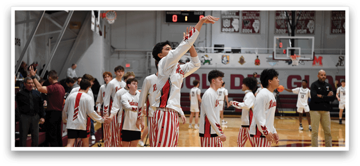 A group of young men wearing red and white striped pants are standing on a basketball court. One of the men is holding a basketball and appears to be getting ready to shoot it. The other men are watching and waiting for their turn to play. AI generated content