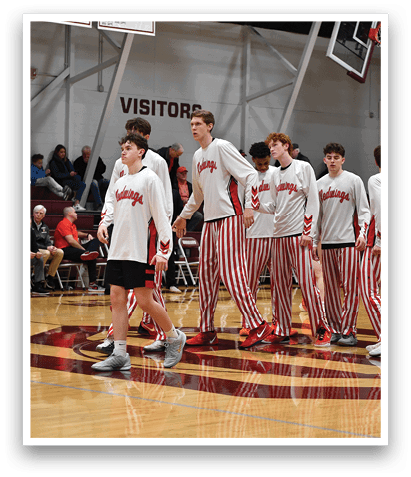 A group of young men wearing red and white striped pants are walking on a basketball court. AI generated content