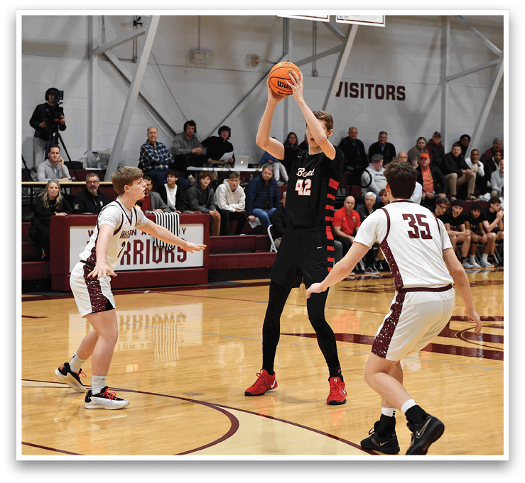 A basketball game is taking place with a player in the air attempting to shoot the ball. The game is being watched by a crowd of people who are seated on chairs. AI generated content