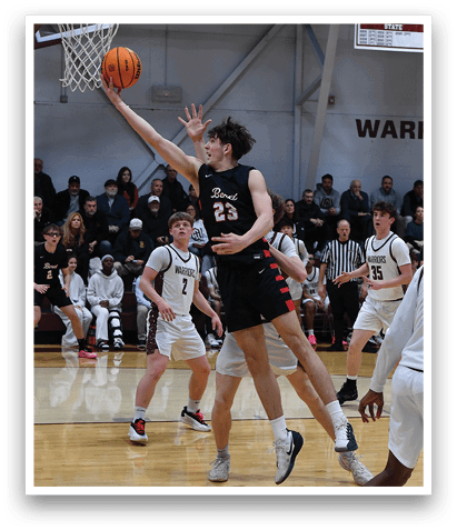 A basketball game is in progress with a player in the air attempting to score a basket. The crowd is watching intently as the players compete. AI generated content