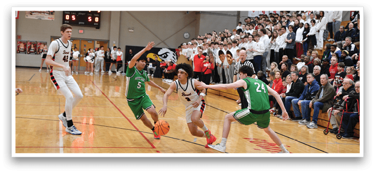 A basketball game is in progress with a group of men playing. One man is attempting to block a shot while another man is trying to get past him. The crowd is watching the game intently. AI generated content