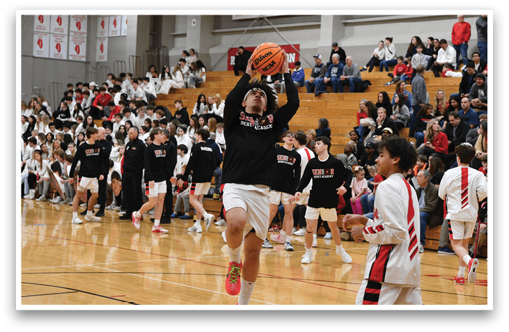 A basketball game is taking place with a player in the air attempting to dunk the ball. The crowd is watching intently as the player jumps. AI generated content