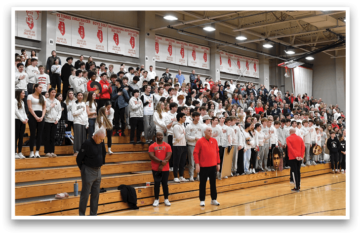 A large crowd of people are sitting in bleachers, watching a basketball game. AI generated content