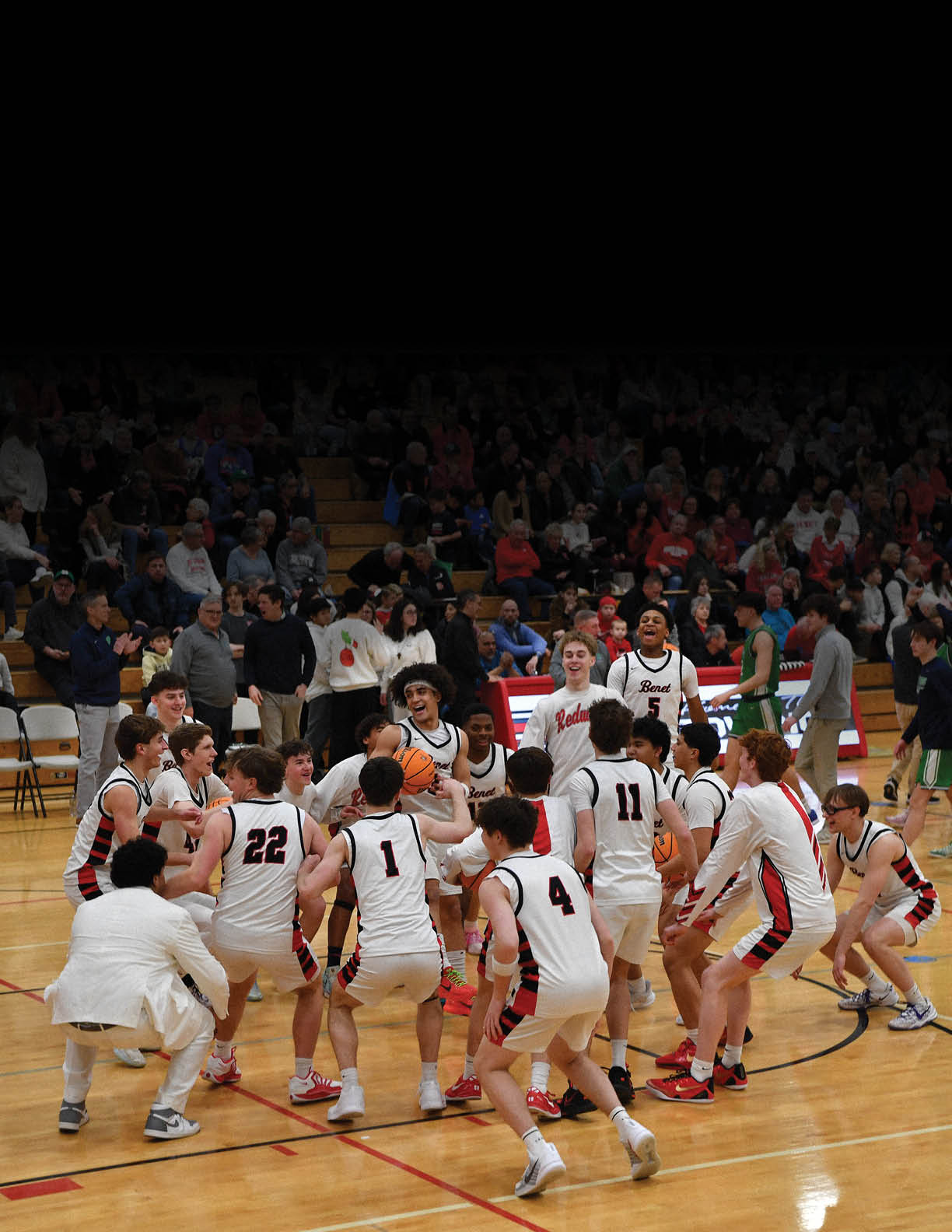 A group of young men in white uniforms are huddled together on a basketball court. AI generated content