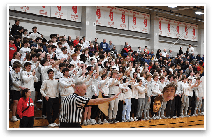 A basketball game is taking place with a crowd of people watching. A boy is holding a basketball in his hands, and a man in a striped shirt is standing nearby. The spectators are seated on benches, and there is a referee present to oversee the game. AI generated content