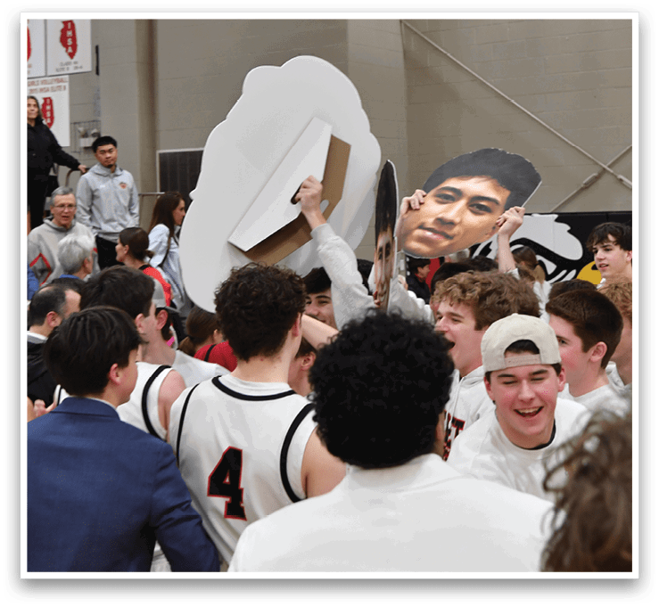 A group of people are gathered in a gym, with a man holding a cardboard cutout of another man's face. AI generated content