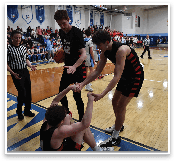 A group of men are playing basketball on a court. One man is holding a basketball while another man is holding his hand. AI generated content