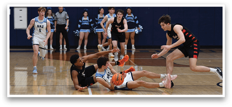 A group of people are playing basketball on a court. One player is diving for a ball while others are running around. The scene is lively and competitive. AI generated content