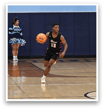 A basketball game is taking place with a player in the foreground holding a basketball. The player is running towards the basket while a group of people watch from the sidelines. AI generated content