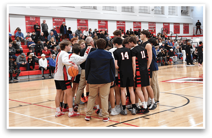 A group of young men huddle together on a basketball court, holding a basketball. AI generated content