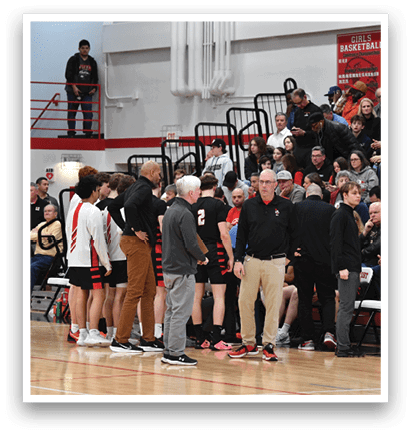A group of people are standing on a basketball court, engaged in a conversation. AI generated content