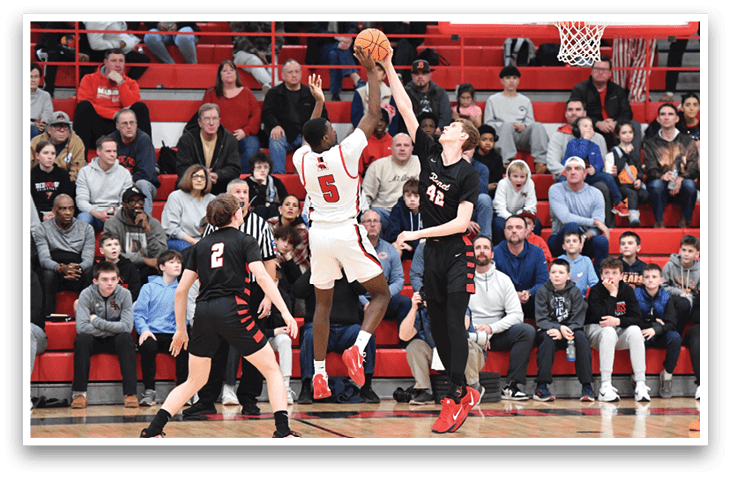 A basketball game is taking place with a player in the air attempting to score a basket. The crowd is watching intently as the player jumps to make the shot. AI generated content