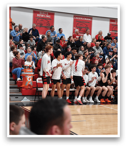 A group of young men are playing basketball on a court, with a crowd of people watching from the stands. AI generated content