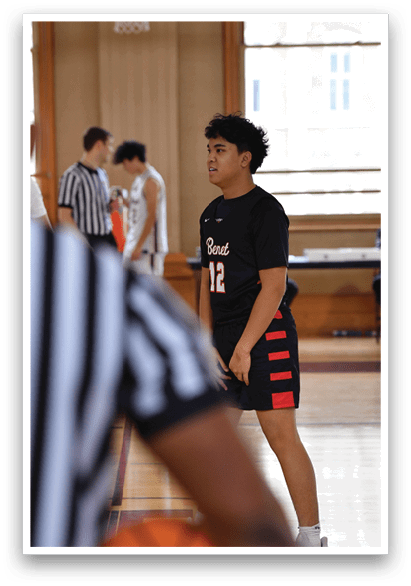 A basketball player wearing a black shirt and red shorts is standing on a basketball court. AI generated content