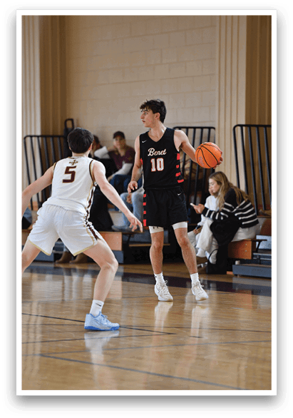 A basketball player in a black shirt and shorts is holding a basketball while another player runs by. AI generated content