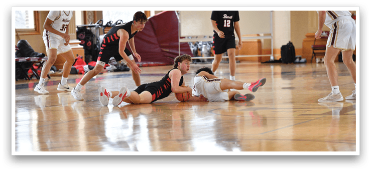 A basketball game is in progress with players on the court. One player is lying on the ground with a basketball in his hand. AI generated content