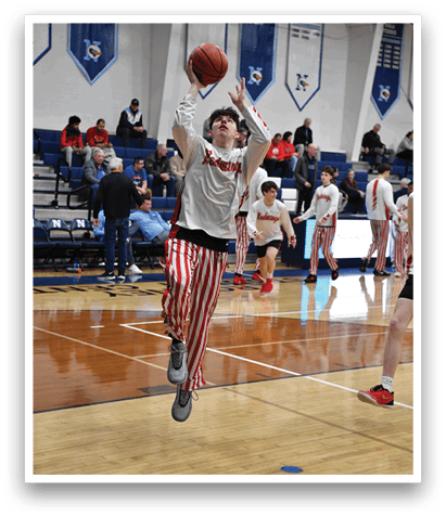 A basketball player in a striped shirt and red socks leaps to block a shot. AI generated content