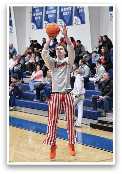A basketball player in a grey and red striped outfit is jumping to catch a basketball. AI generated content