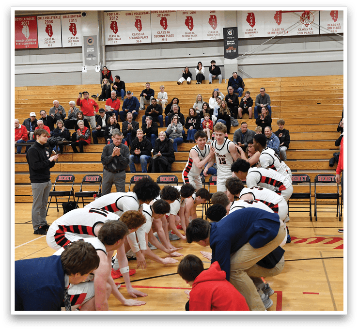A group of young men are on a basketball court, kneeling in front of a crowd of people. AI generated content