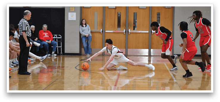 A basketball player is on the floor holding a basketball while other players look on. AI generated content