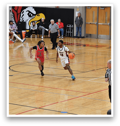 A basketball game is in progress with a group of young men playing. One player is running with a basketball while others are chasing him. A referee is also present, watching the game closely. AI generated content