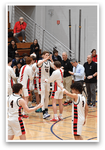 A group of young men in uniforms are standing on a basketball court, engaged in a conversation with each other. AI generated content