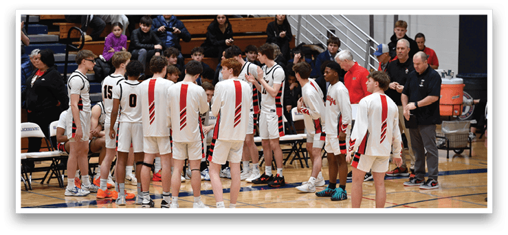 A group of young men wearing red and white uniforms are standing on a basketball court. They are gathered around each other, possibly discussing their game strategy. The court is surrounded by a crowd of spectators, some of whom are sitting on chairs and benches. There are also a few bottles visible in the scene, likely containing water or sports drinks for the players. AI generated content
