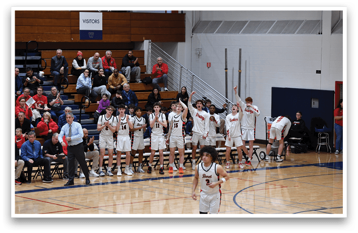A group of young men are standing on a basketball court, some of them holding their hands up. They are likely participating in a basketball game or practice. The scene takes place in a gymnasium, with a crowd of spectators watching the event. The spectators are seated on chairs that are arranged around the court. AI generated content