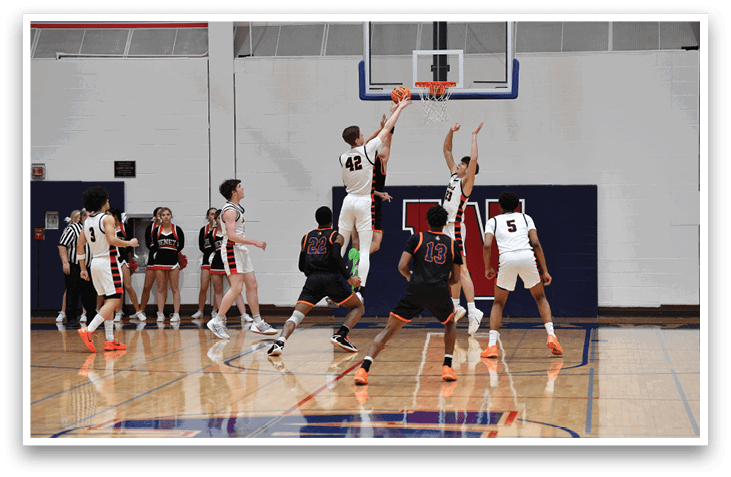 Basketball players on a court, one of them jumping to block a shot. AI generated content