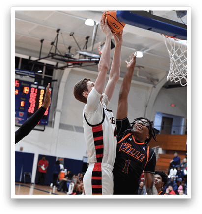 Two men are playing basketball, one of them is jumping to block a shot. AI generated content