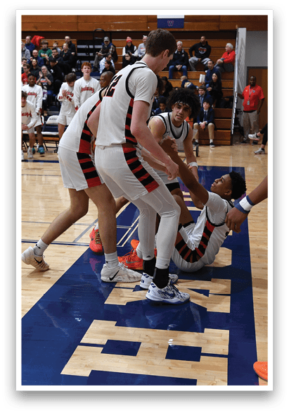 A group of people are playing basketball on a court. One player is falling to the ground while another player is holding his leg. The scene is intense and competitive. AI generated content