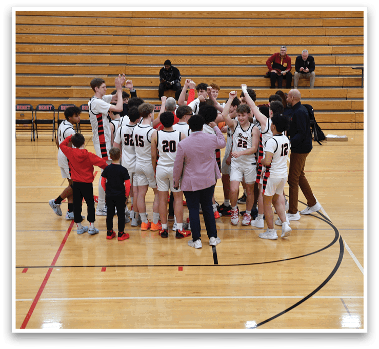 A group of young men huddle together on a basketball court, celebrating a victory. AI generated content