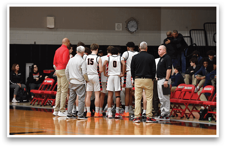 A group of basketball players are standing on the court, wearing uniforms and holding their basketballs. They are gathered in a circle, possibly discussing their game strategy or preparing for a play. The players are positioned around the court, with some closer to the foreground and others further back. The scene is set in a gymnasium, with a clock visible on the wall. AI generated content