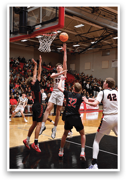 A basketball game is in progress with a player attempting to block a shot. AI generated content