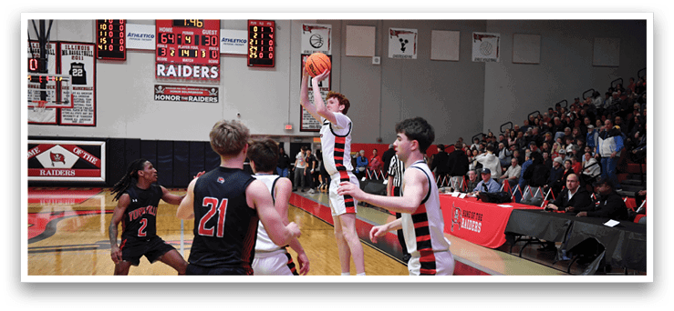 A basketball game is in progress with a player jumping to block a shot. AI generated content